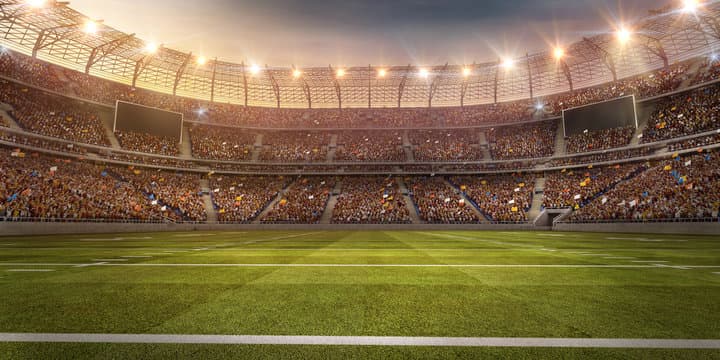 A floodlit football stadium filled with spectators